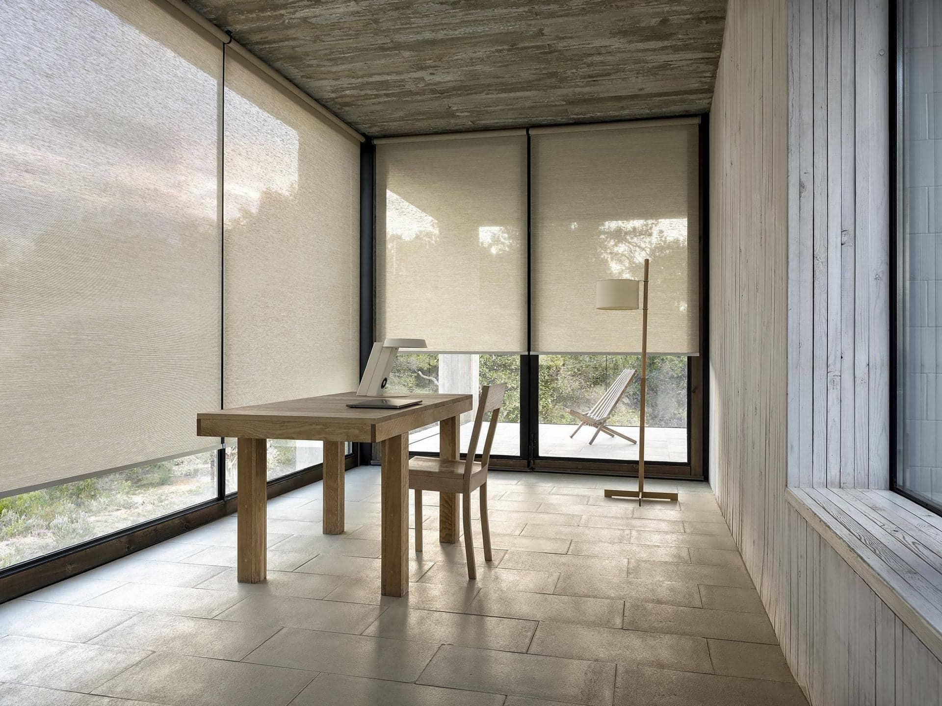 A roller shade lowered over a wide living room window